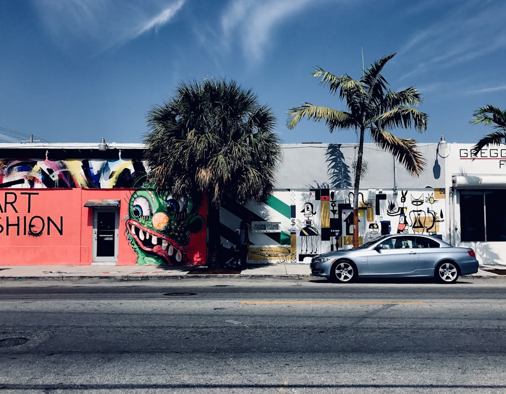 une voiture garée devant un immeuble avec des graffitis dessus