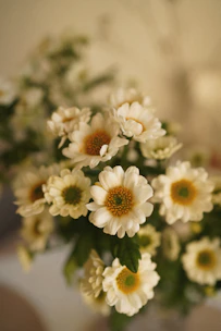 a vase filled with white and yellow flowers