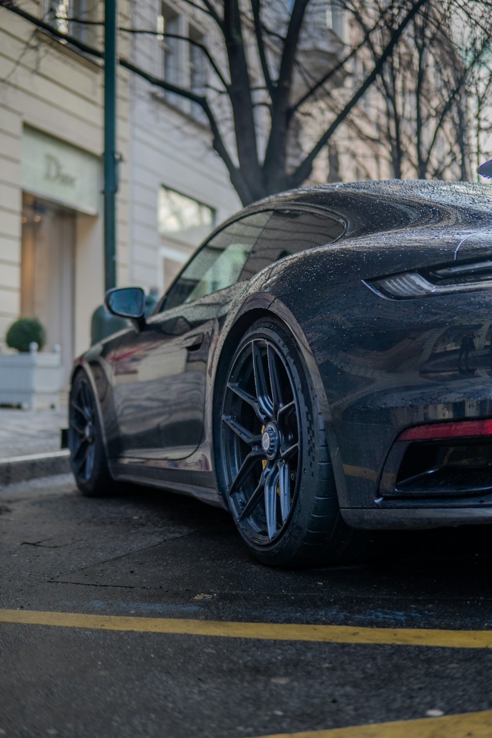 a grey sports car parked on the side of the road