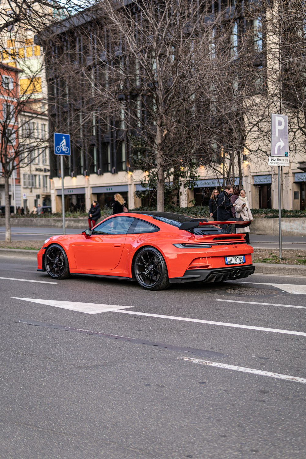 an orange sports car parked on the side of the road