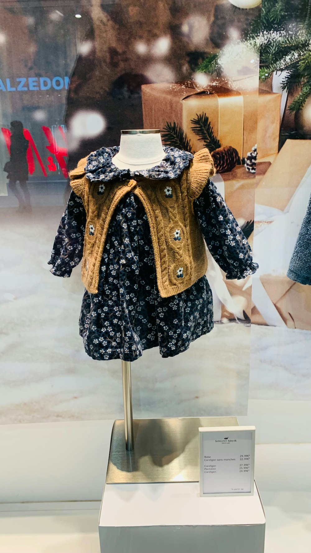 a dress and jacket on display in a glass case
