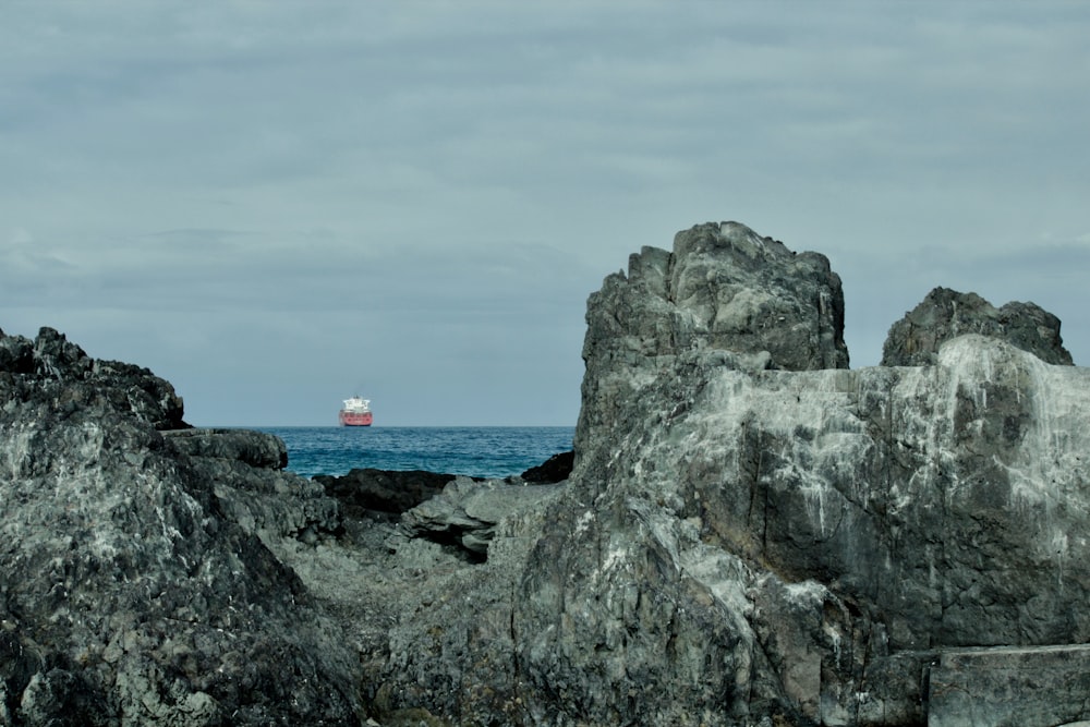 a red and white boat is in the distance on the ocean