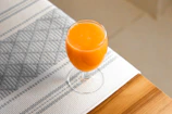 a glass of orange juice sitting on top of a table