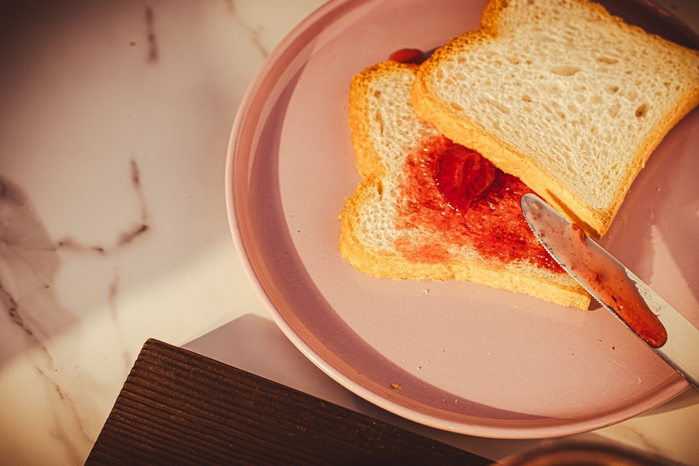 a plate with a piece of toast and a strawberry jam on it