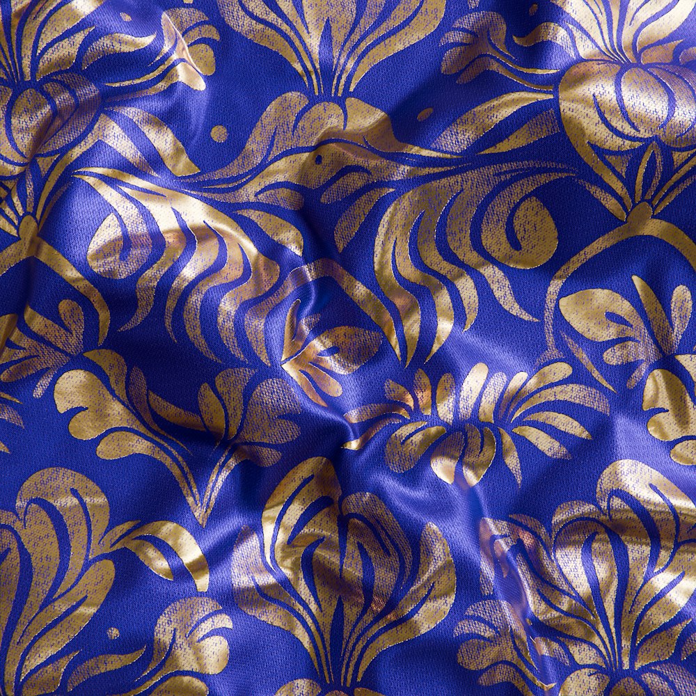 a close up of a blue and gold fabric