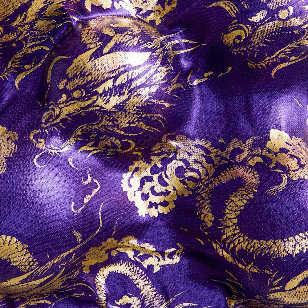 a close up of a purple and gold fabric