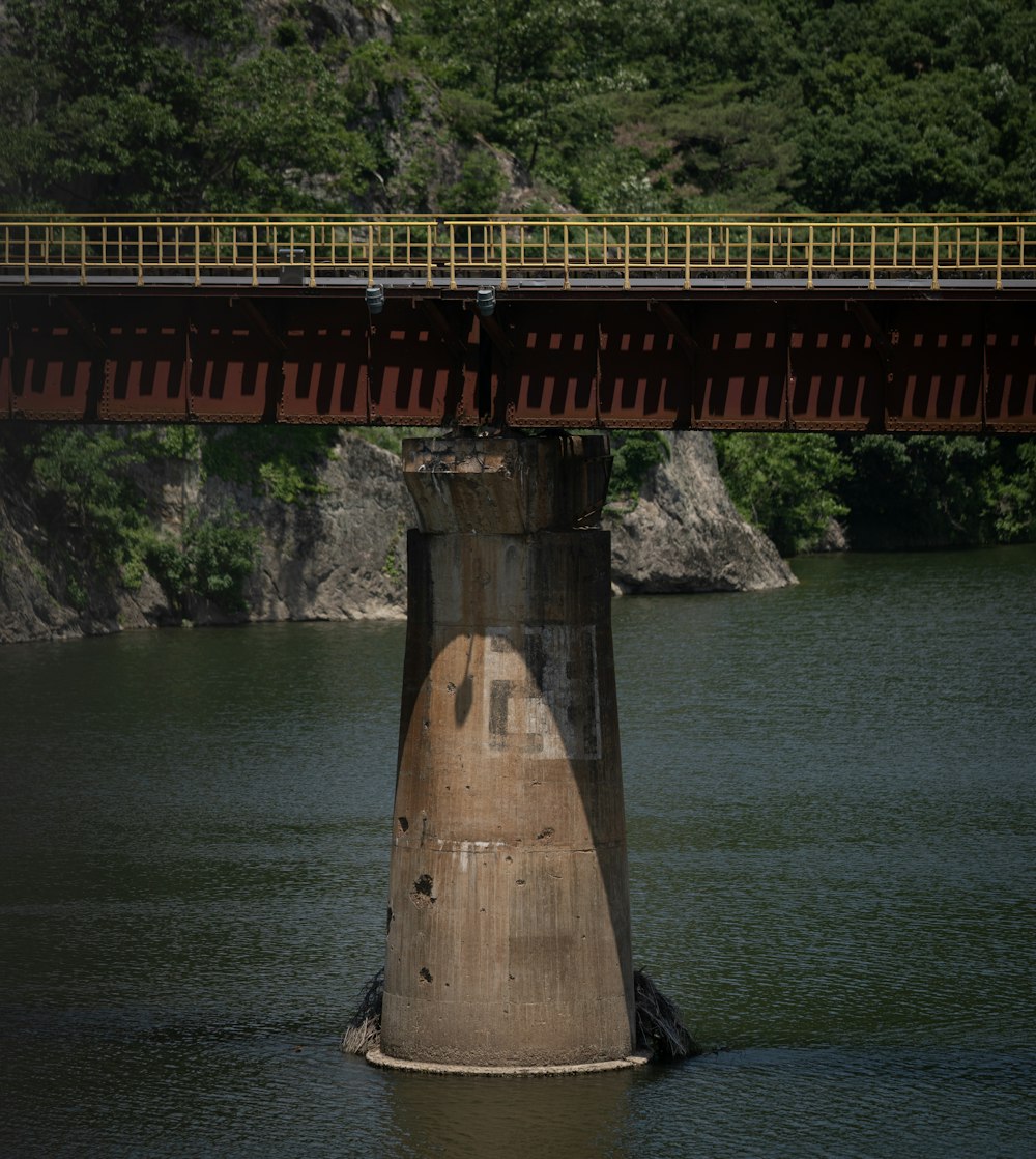 a bridge over a body of water with trees in the background