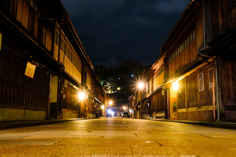 eine Straße bei Nacht mit ein paar Autos, die am Straßenrand geparkt sind