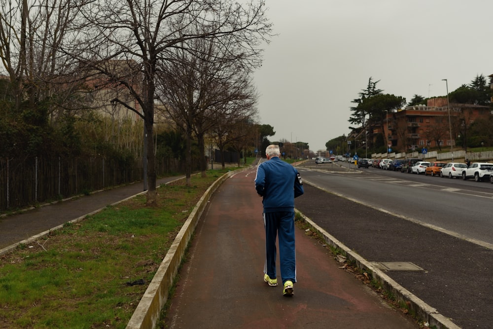 a man in a blue jacket is walking down the street