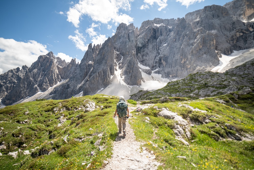 a man hiking up a trail in the mountains