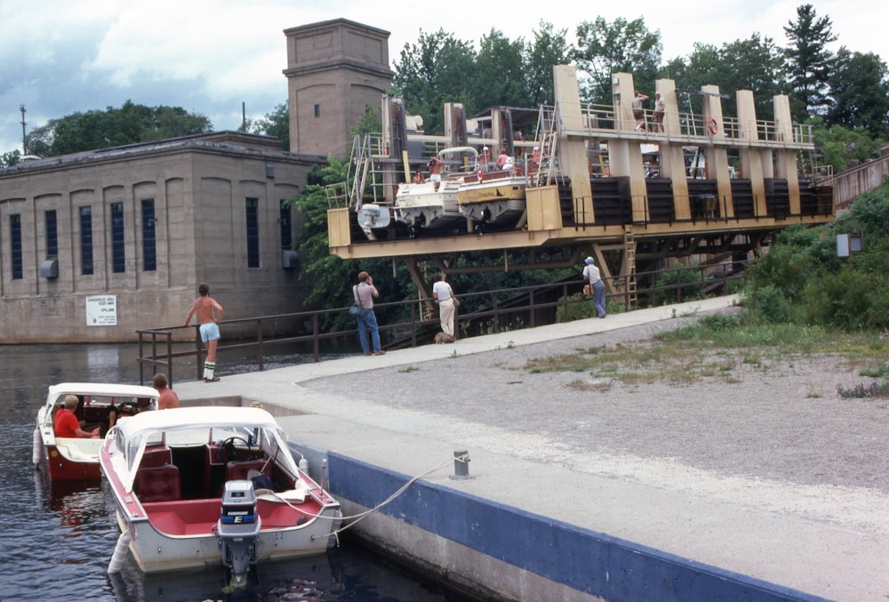 a group of people standing on a dock next to a boat