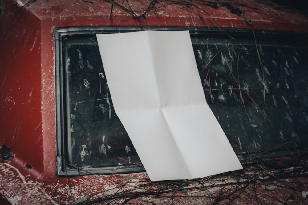 a piece of paper sticking out of the side of a red car