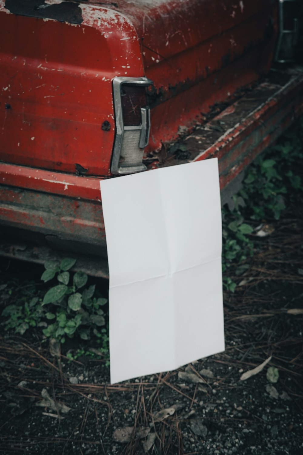 a piece of paper sitting on the ground next to a car