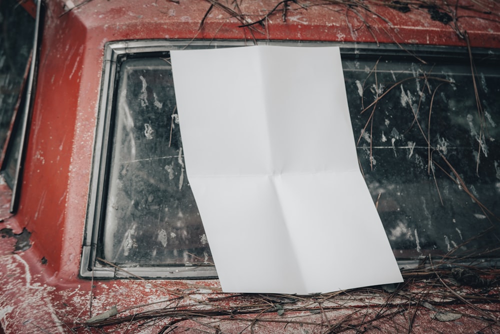 a piece of paper hanging from the side of a red car