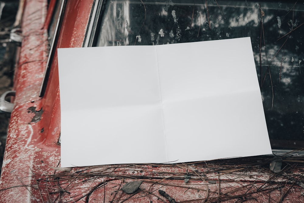 a piece of paper sitting on top of a red car