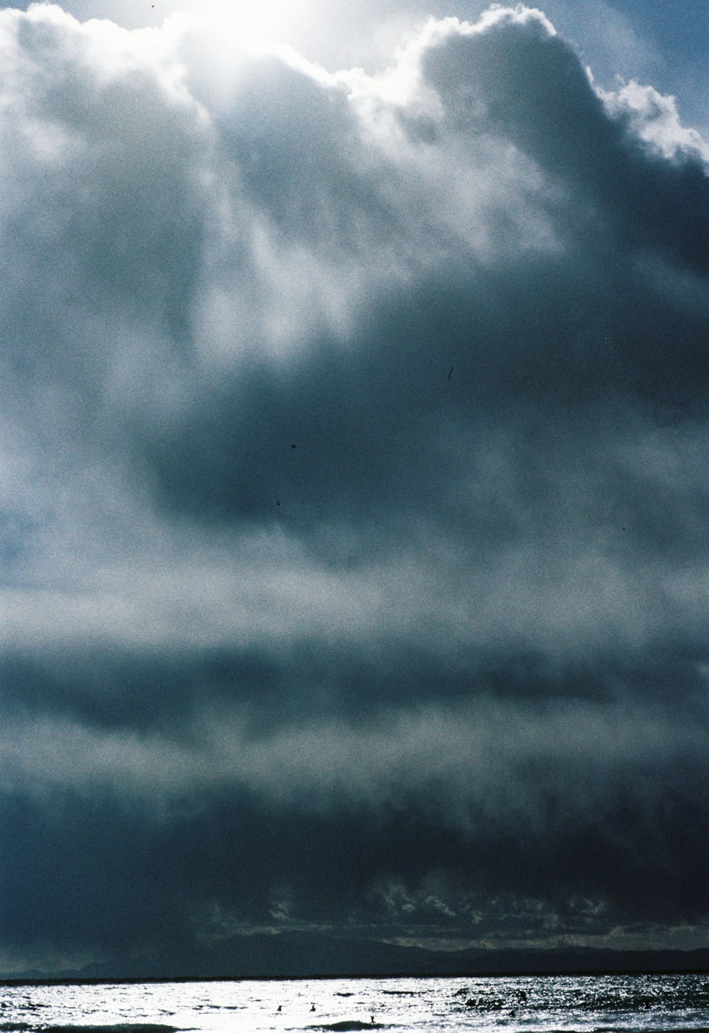 a person on a surfboard in the ocean under a cloudy sky