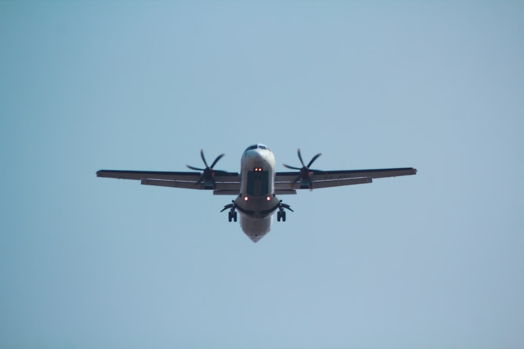 a large airplane flying through a blue sky, AT76 operated by US-Bangla Airlines.
