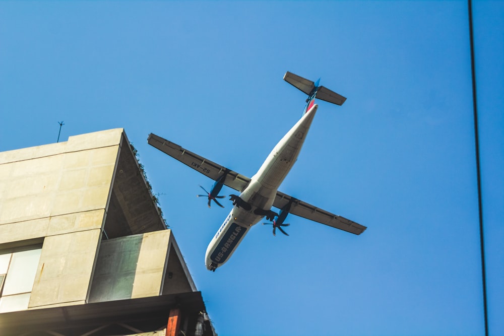 an airplane flying over a building in the sky