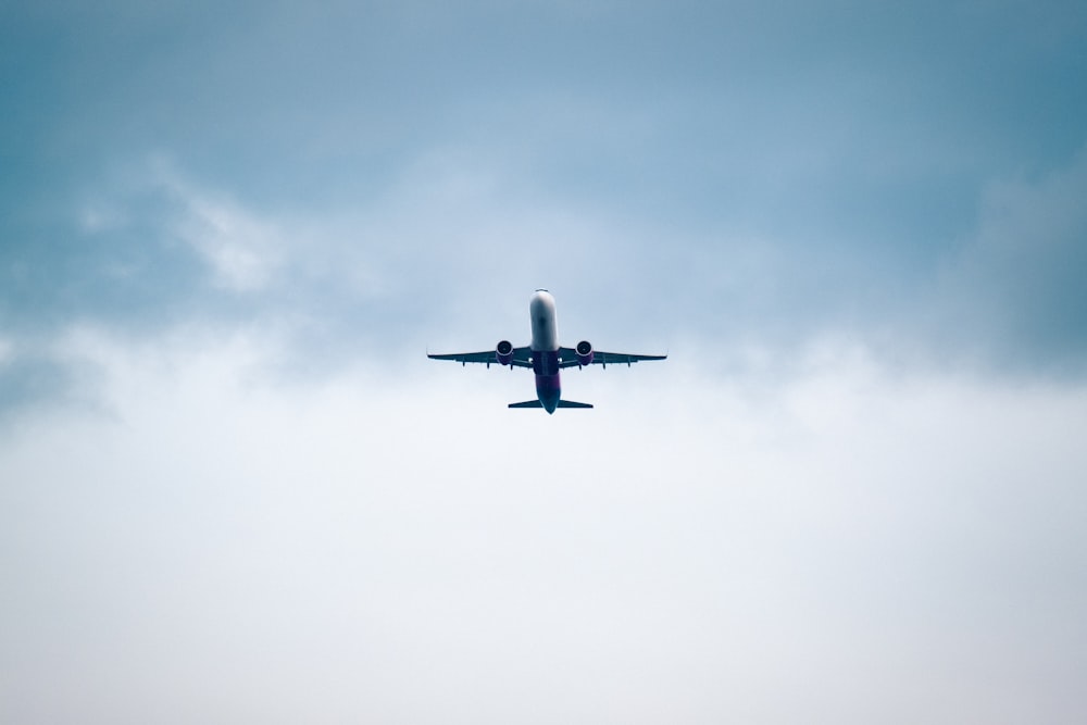 a large jetliner flying through a cloudy blue sky