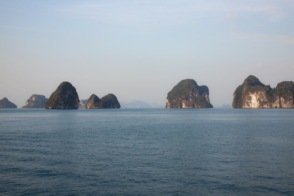 a group of rocks in the middle of a body of water