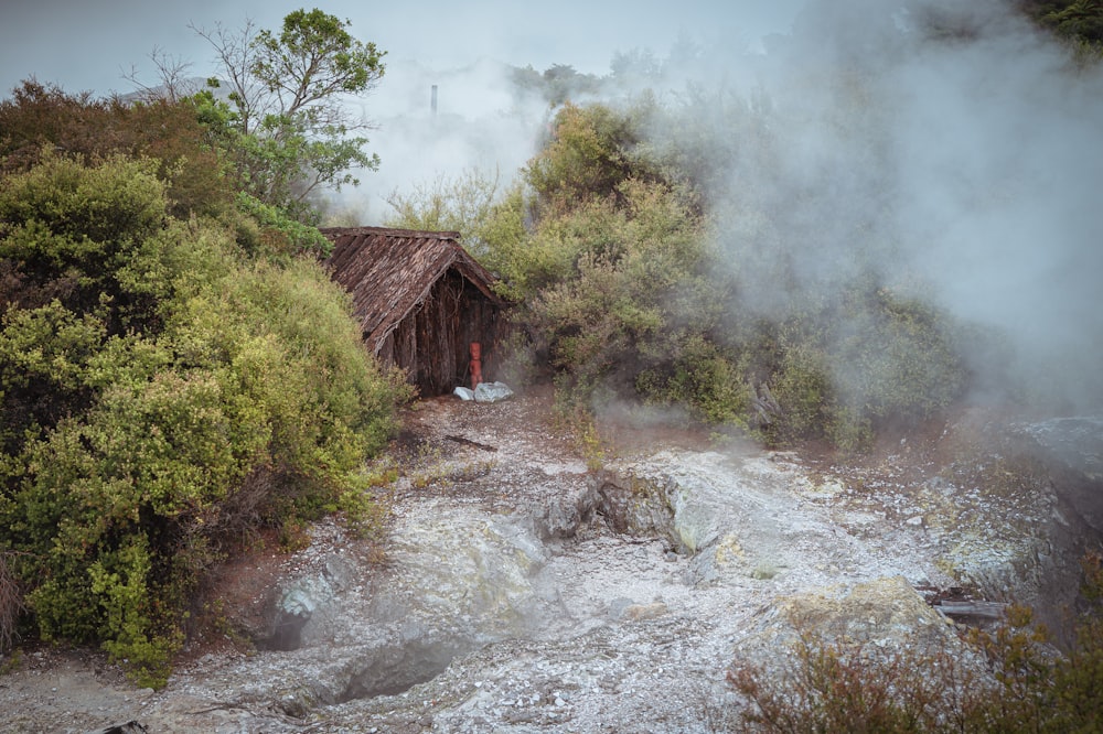 a hut in the middle of a river with steam coming out of it