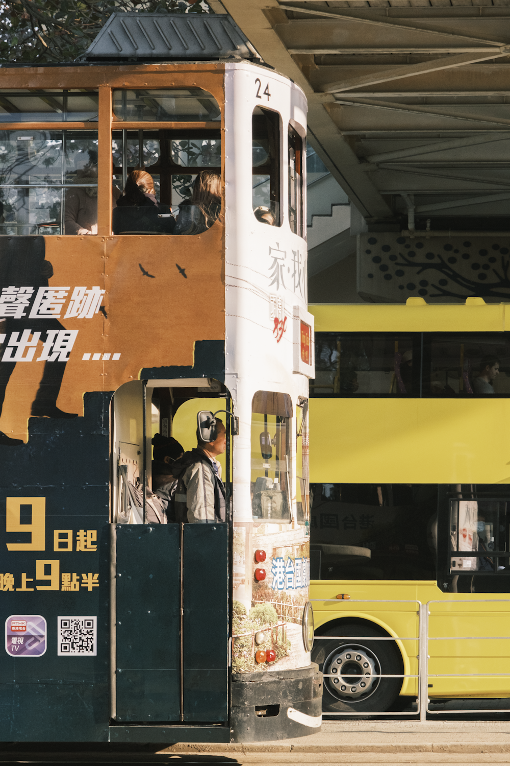 um ônibus amarelo de dois andares dirigindo por uma rua