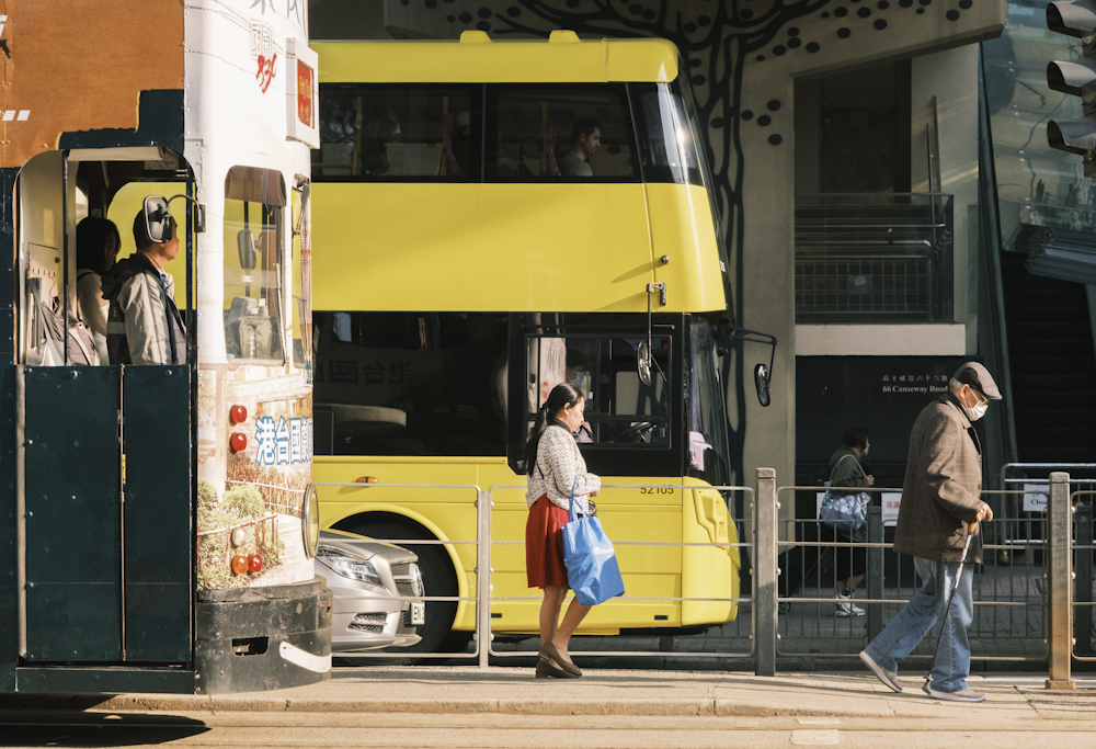 Un par de personas que están paradas frente a un autobús