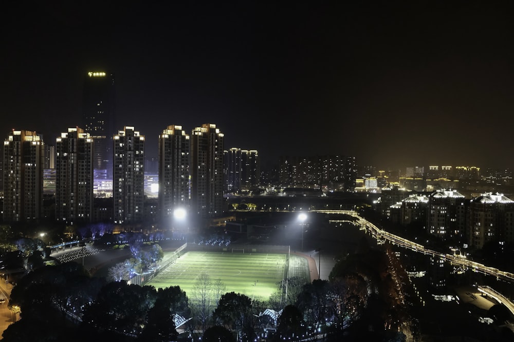 a night view of a city with a soccer field