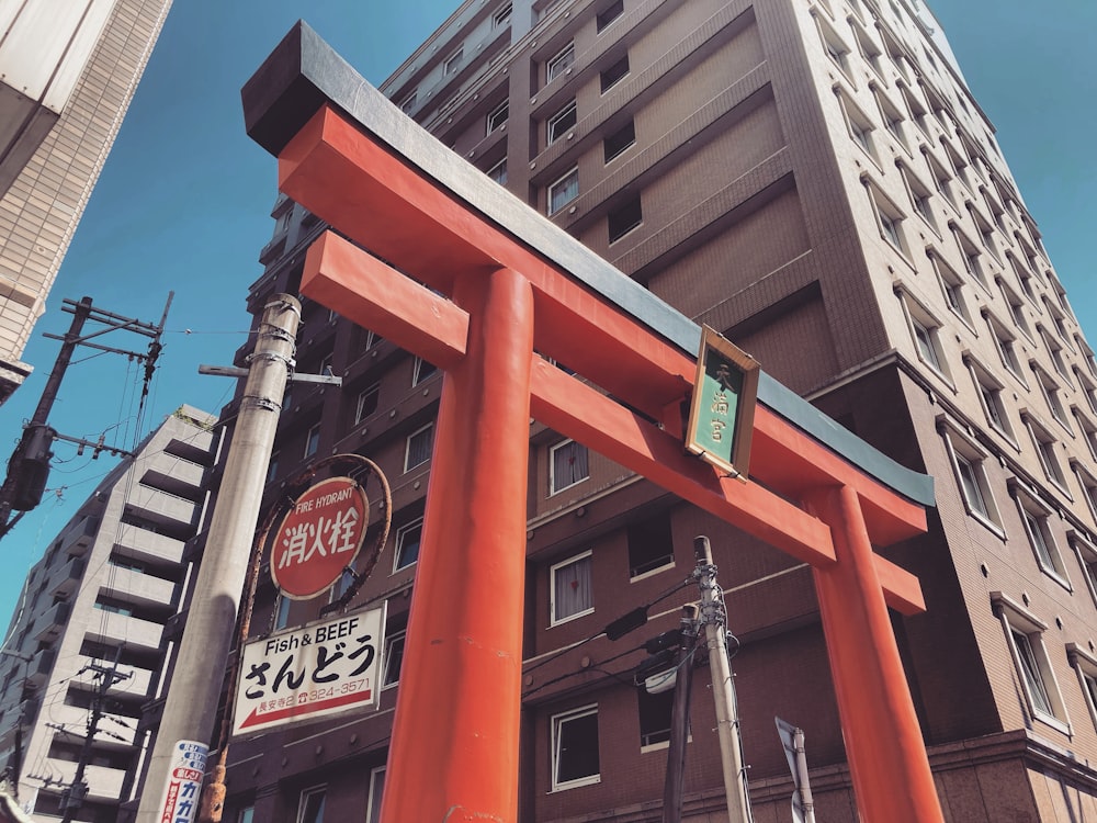 a tall building with a large red gate in front of it