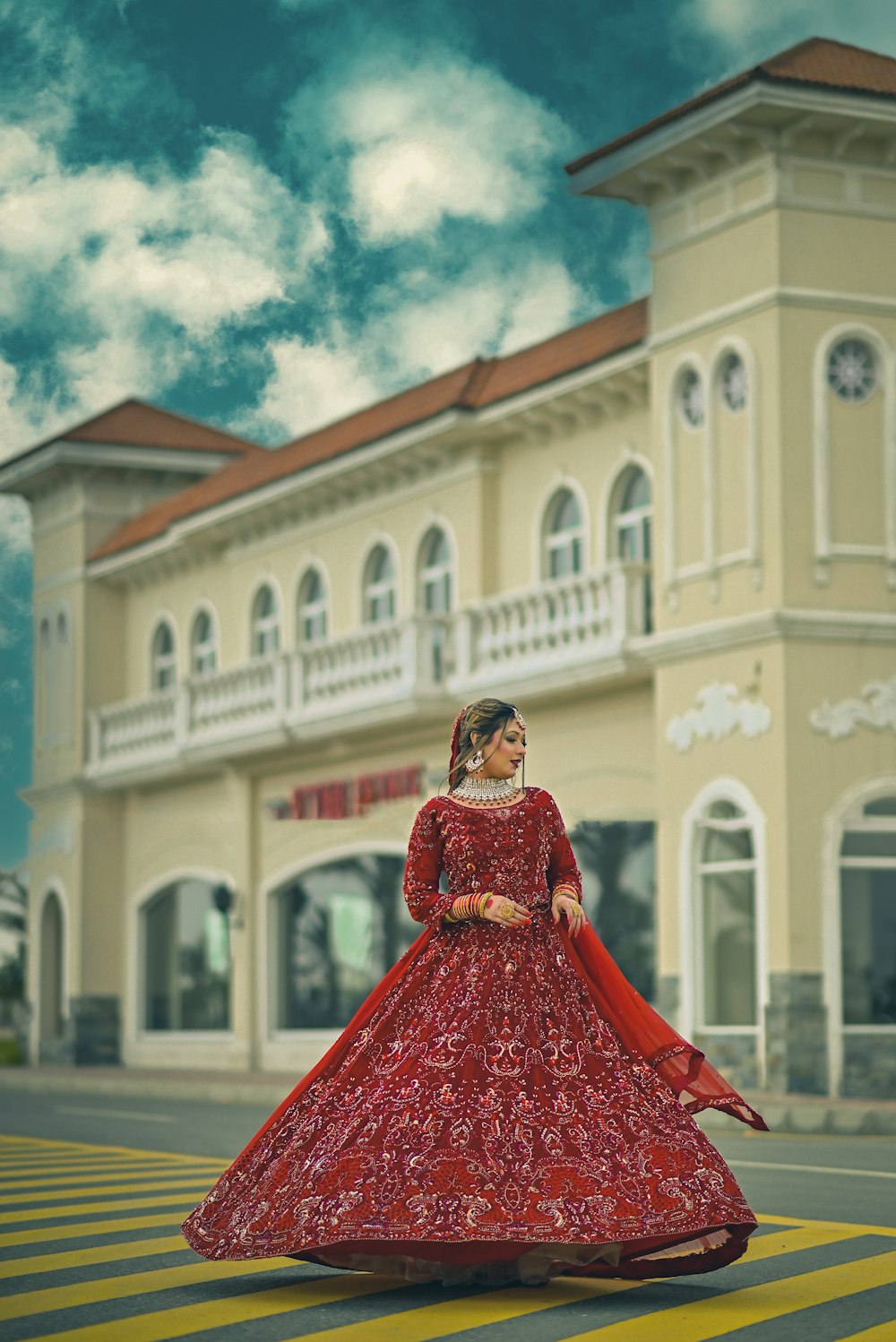 a woman in a red dress standing in front of a building