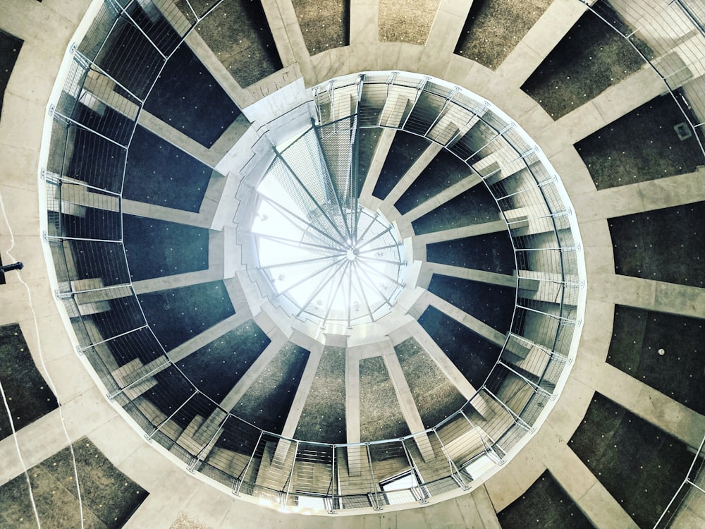 looking up at a circular metal structure with a skylight