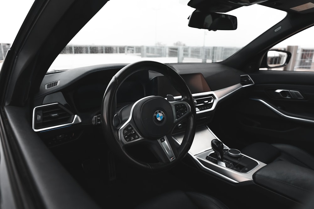 the inside of a car with a steering wheel and dashboard