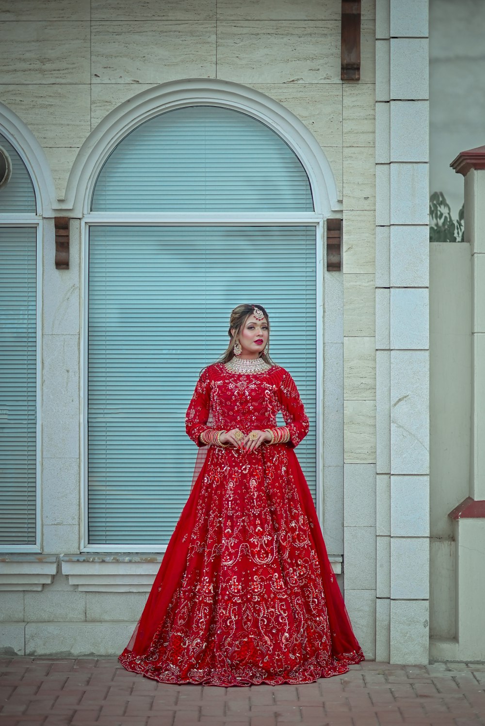 a woman in a red dress standing in front of a building