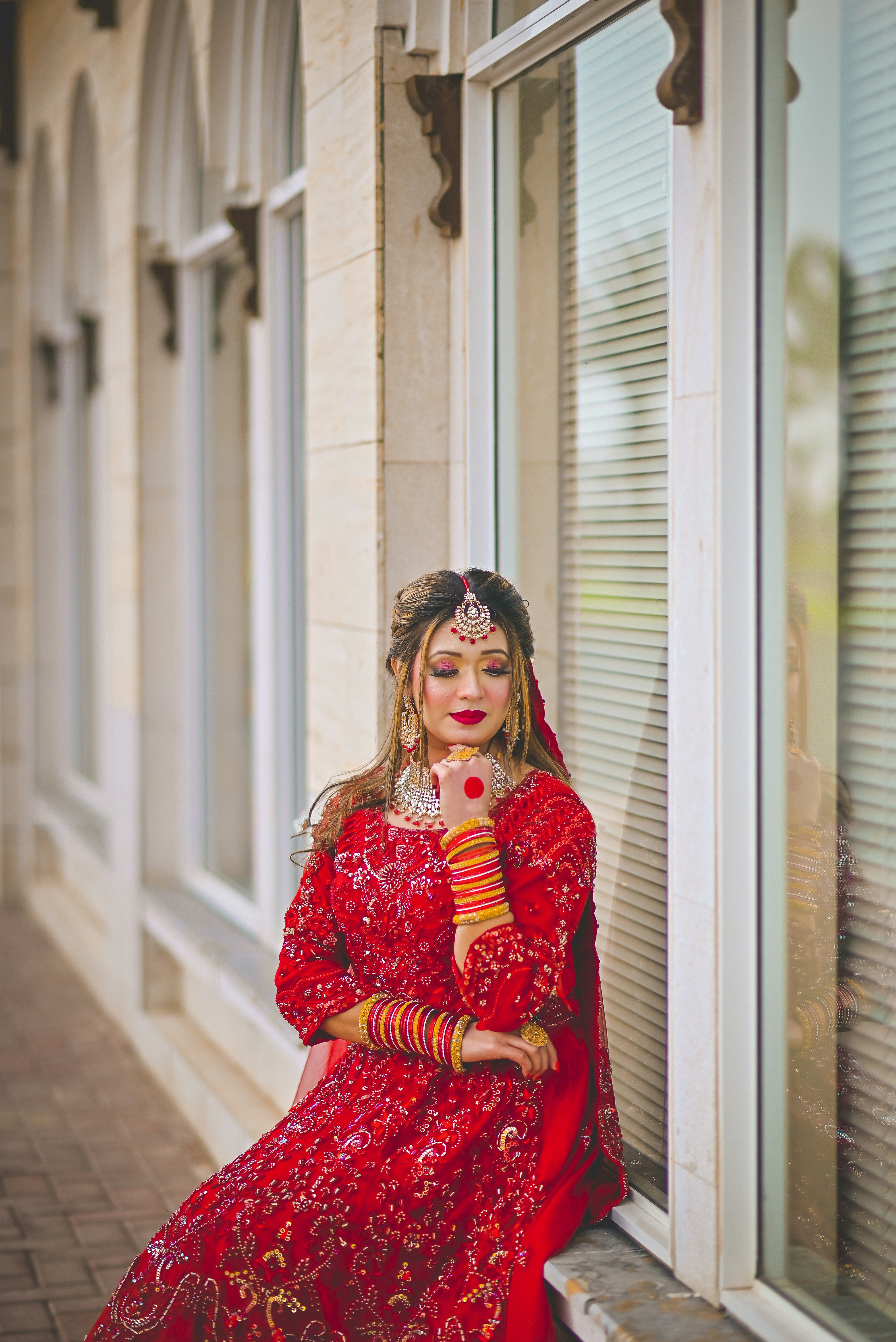 a woman in a red dress sitting on a window sill