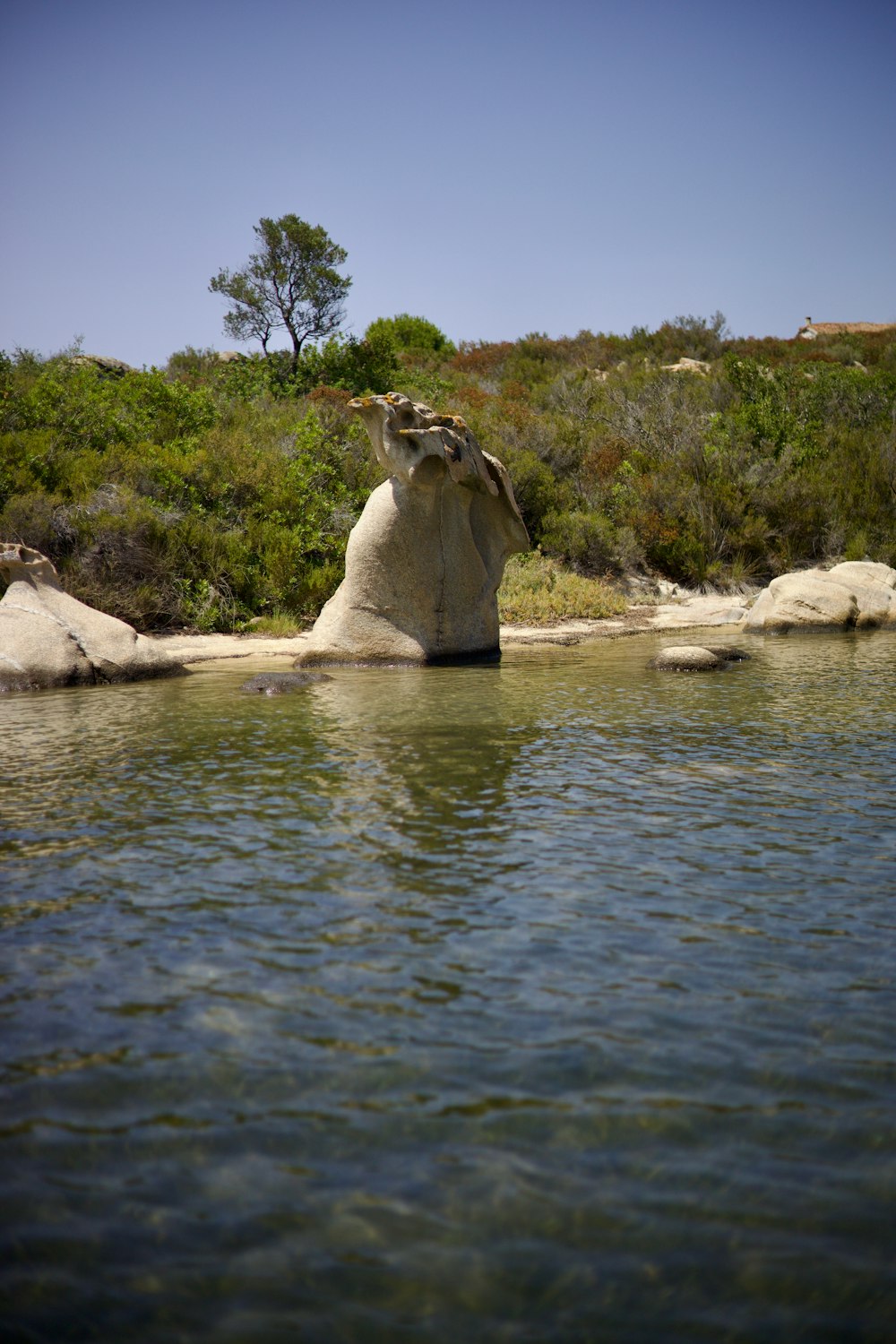 a large rock in the middle of a body of water