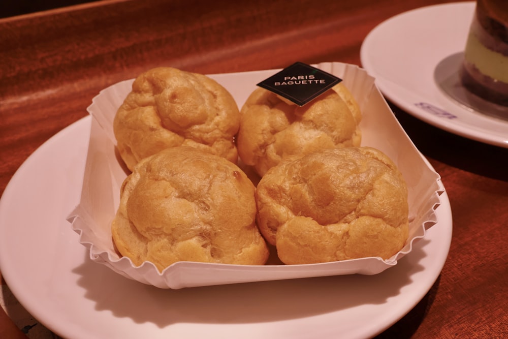 a white plate topped with pastries on top of a wooden table