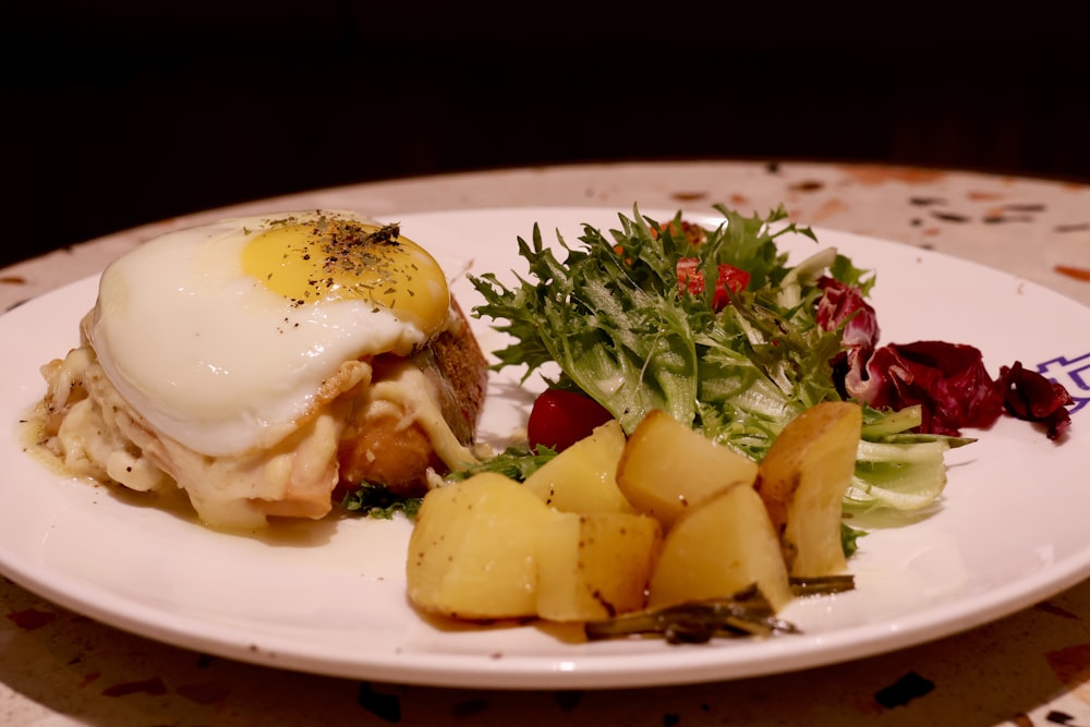 a white plate topped with food and vegetables