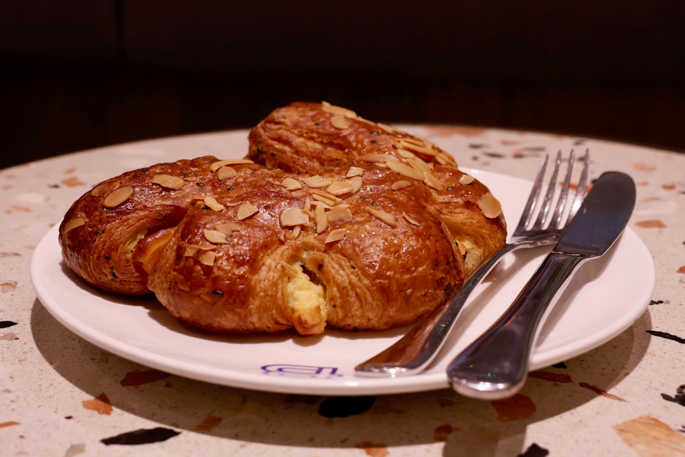 a white plate topped with pastries next to a fork