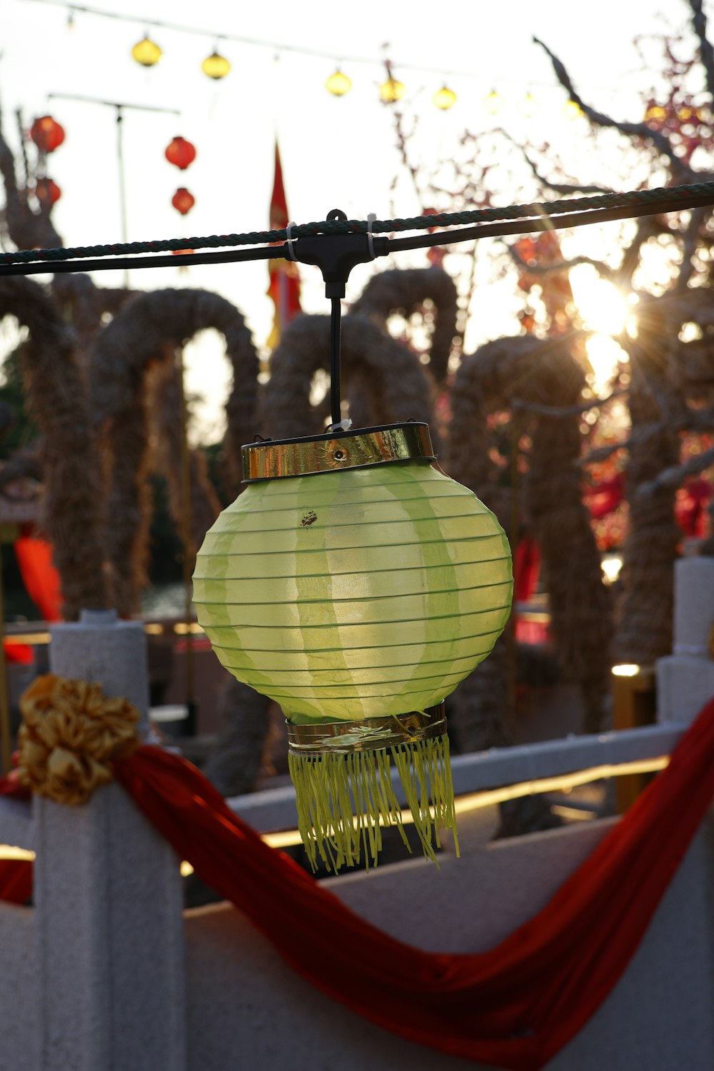 a chinese lantern hanging from a wire in front of a fence