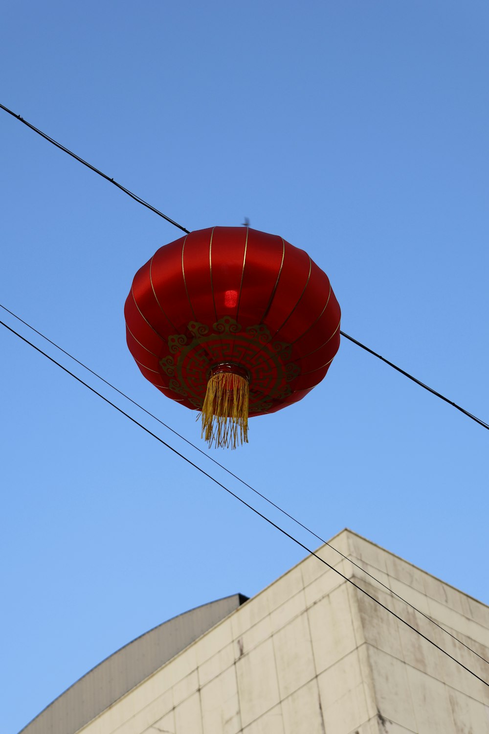 une lanterne rouge suspendue à un fil devant un bâtiment