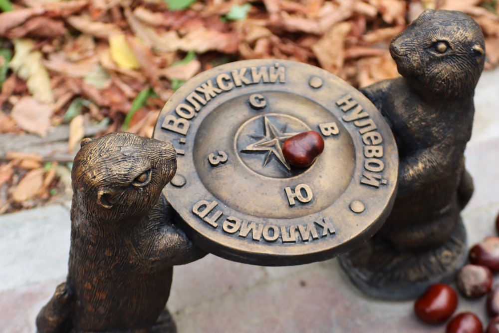a statue of two bears holding a compass