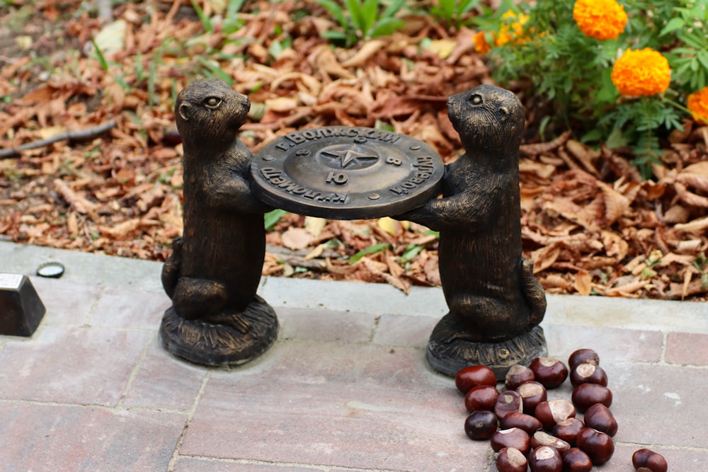 a statue of two bears holding a plate of nuts