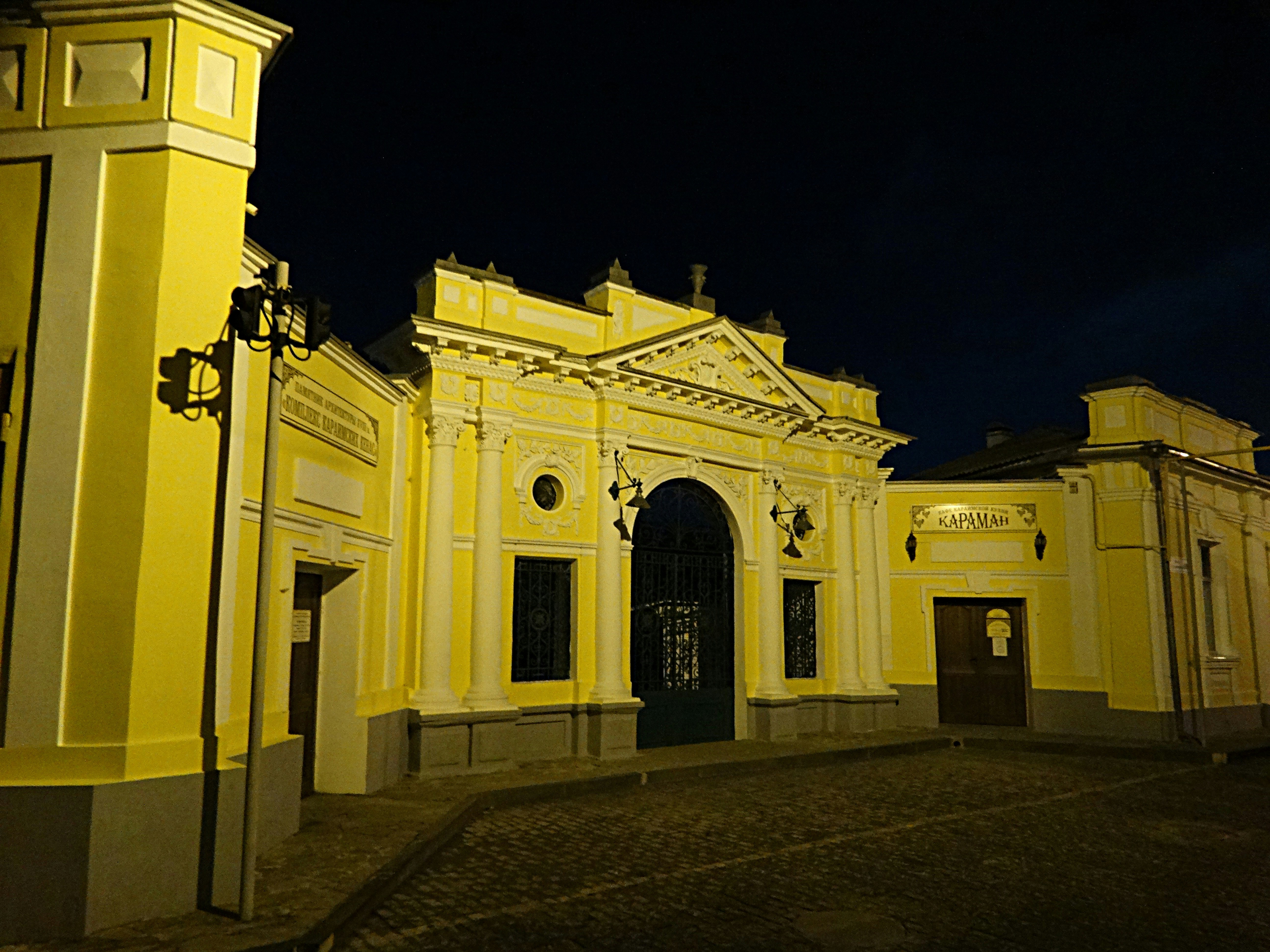 a yellow building with a clock on the front of it