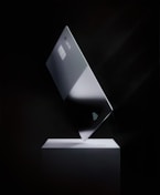 a silver credit card on top of a white stand