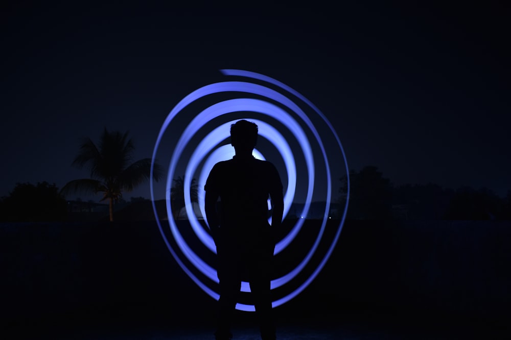 a man standing in front of a blue light