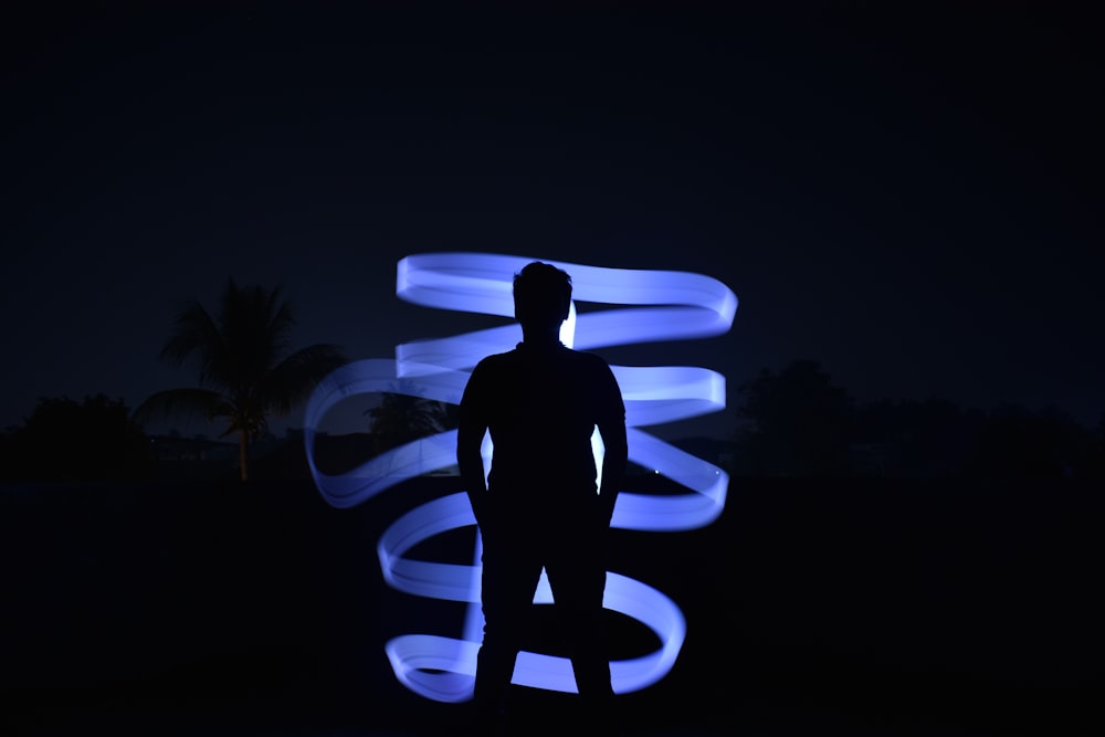 a man standing in front of a sculpture at night