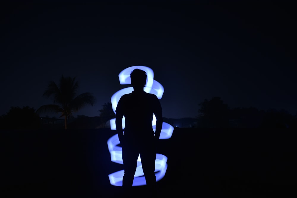 a man standing in front of a blue light