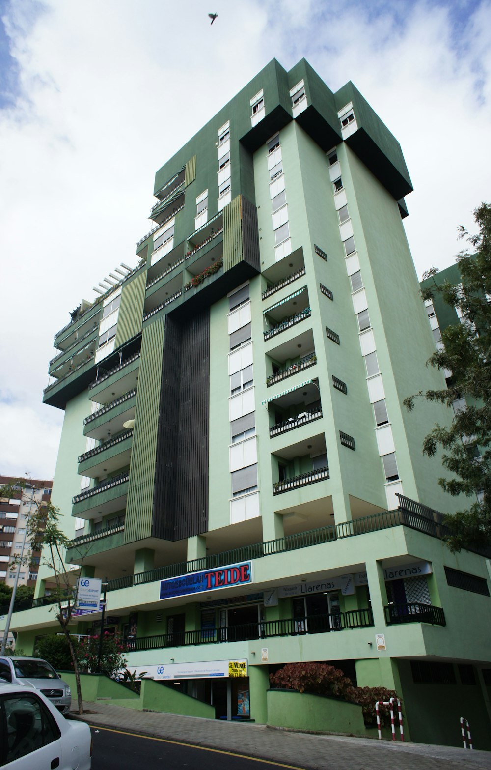 Un edificio alto y verde con balcones y balcones