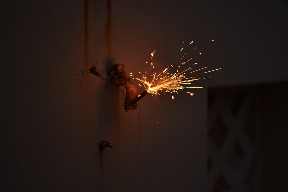 a person holding a sparkler on a wall