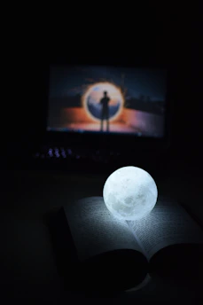 an open book with a glowing light on top of it